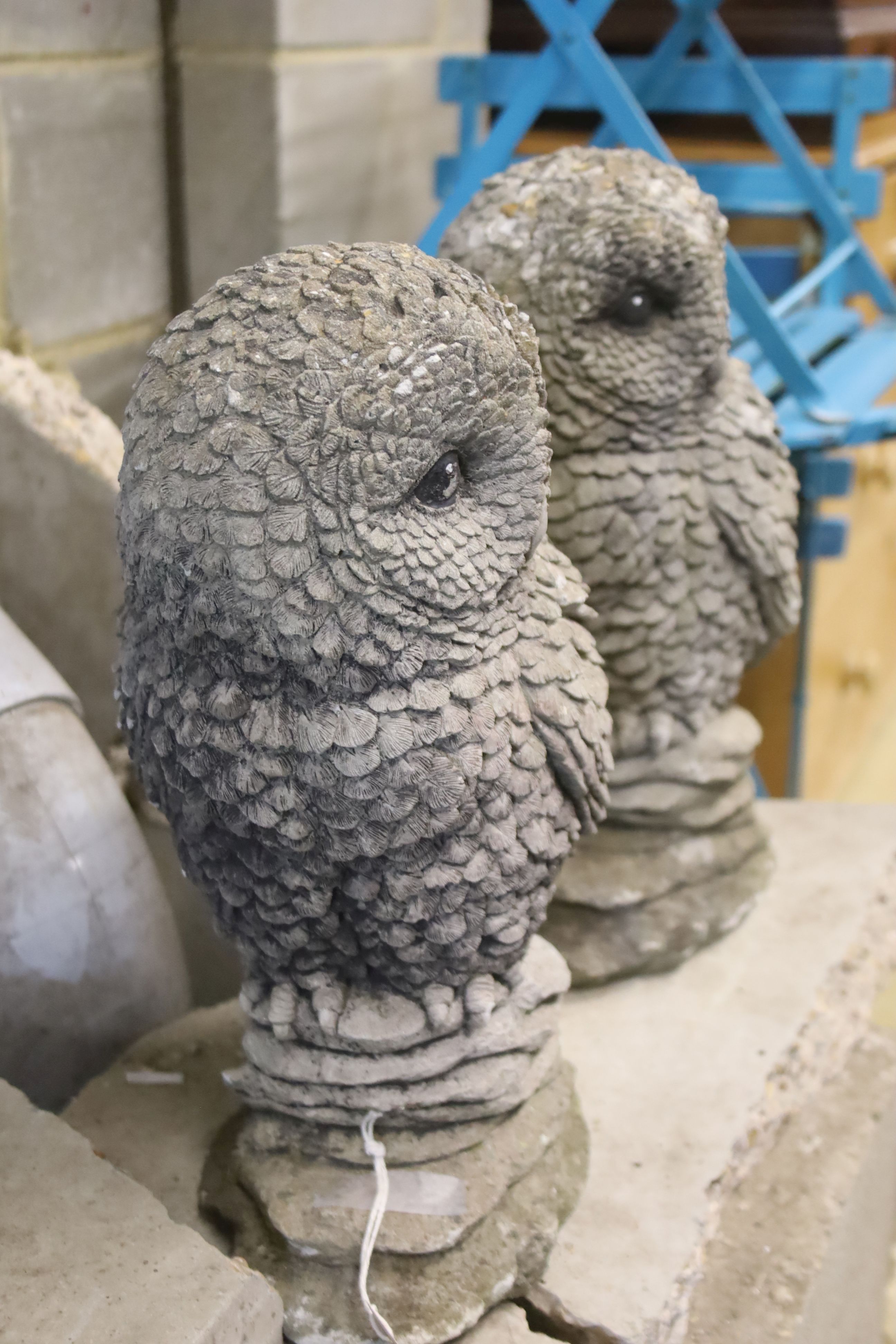 A pair of reconstituted stone garden ornaments modelled as owls, height 41cm